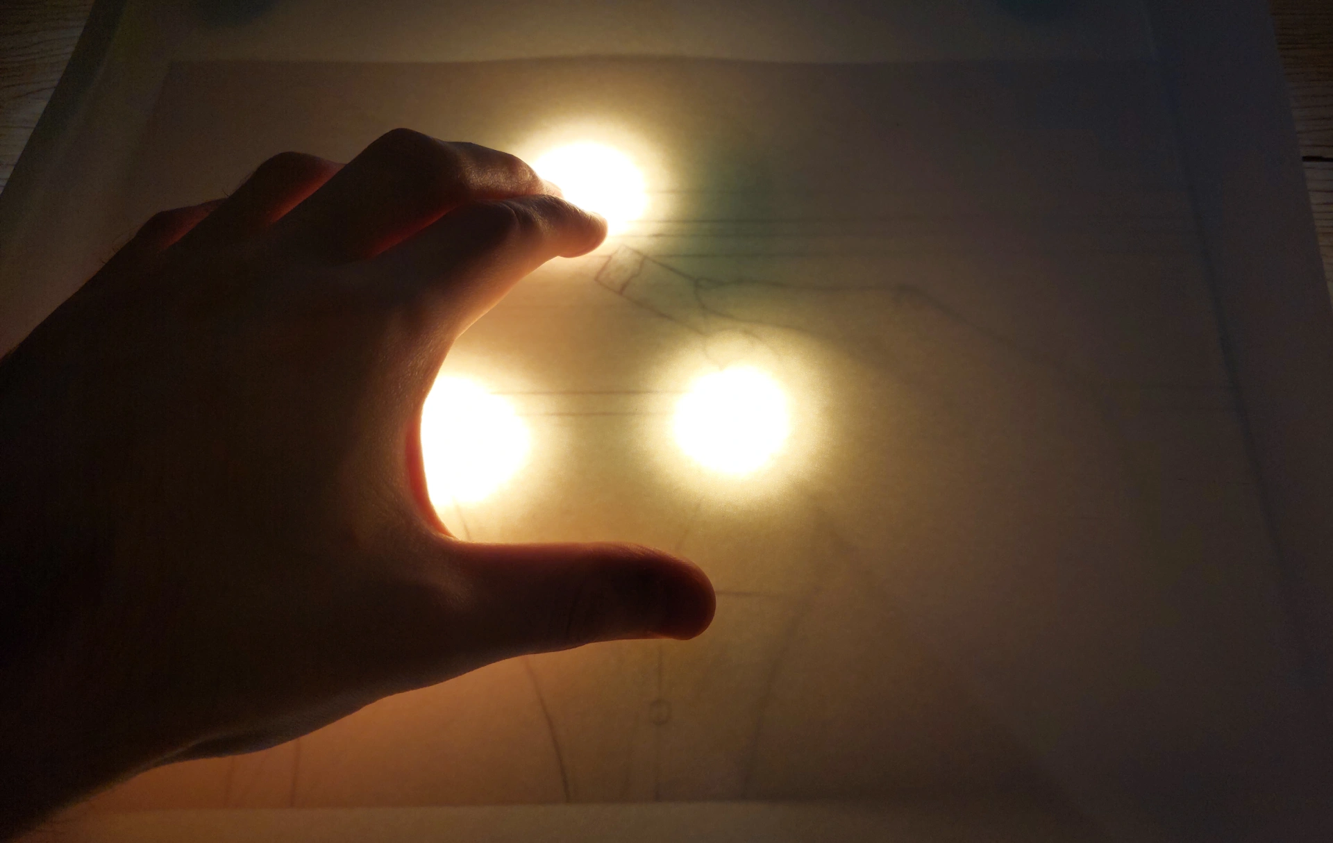 The complete DIY light box setup in action, with the LED lamp illuminating a sketch through the glass and a final paper placed on top for tracing.