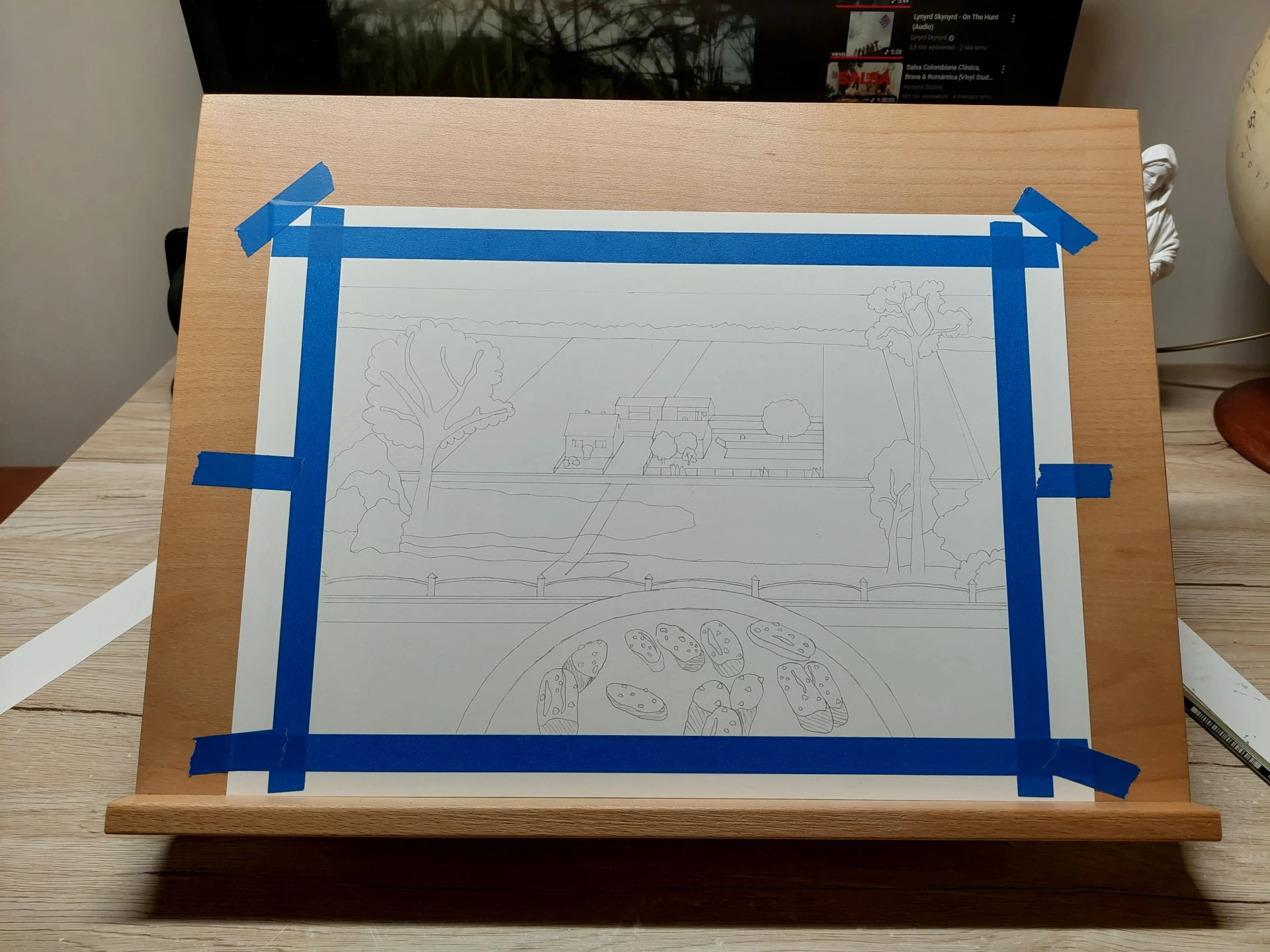 The masked Arches paper secured to a beechwood easel using washi tape.