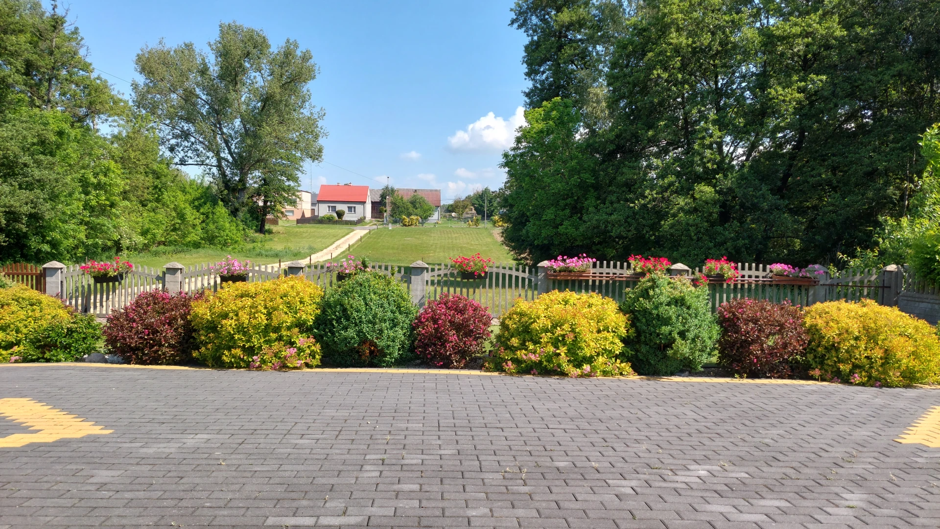 A view from the artist's house showing the large farmstead with two houses, the road, and the surrounding countryside.
