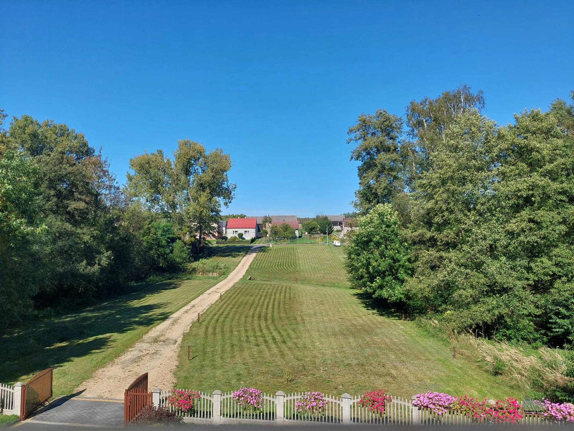 An elevated perspective from a roof window overlooking the same farmstead and the painted landscape area.